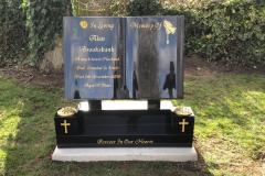 Dark blue granite headstone in cemetery setting